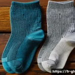양말 세탁 방법 및 관리 팁 - A detailed close-up image of three pairs of socks arranged neatly on a wooden surface, each pair mad...